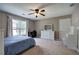 Carpeted bedroom featuring a ceiling fan, a desk, and large windows with curtains, providing ample natural light at 3186 Sail Winds Nw Dr, Acworth, GA 30101