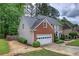 Two-story home featuring a brick facade, attached garage, manicured landscaping, and a cozy, traditional design at 3186 Sail Winds Nw Dr, Acworth, GA 30101