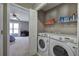 A laundry room leading into a carpeted bedroom with a desk and natural light creating an open and functional living space at 3186 Sail Winds Nw Dr, Acworth, GA 30101