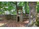 A backyard playhouse surrounded by mature trees and a wood fence at 3186 Sail Winds Nw Dr, Acworth, GA 30101