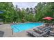 Community pool surrounded by lounge chairs, umbrellas, and lush greenery, offering a relaxing outdoor space at 3186 Sail Winds Nw Dr, Acworth, GA 30101