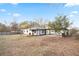 Backyard view featuring a white house with a large yard, a covered patio, and trees at 4605 Doss Cir, Powder Springs, GA 30127