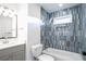 Stylish bathroom showcasing blue tiled walls, a sleek bathtub, a vanity, and modern fixtures at 4605 Doss Cir, Powder Springs, GA 30127