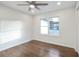 Well-lit bedroom with dark wood floors, a ceiling fan, a window, and white trim at 4605 Doss Cir, Powder Springs, GA 30127