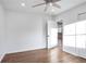 Spacious bedroom featuring dark wood floors, white walls, a ceiling fan, and a view into the kitchen at 4605 Doss Cir, Powder Springs, GA 30127