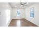 Bright bedroom features hardwood floors, a ceiling fan, and plenty of natural light from two windows at 4605 Doss Cir, Powder Springs, GA 30127
