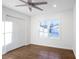 Bright bedroom with dark wood floors, a ceiling fan, a large window, and a white closet at 4605 Doss Cir, Powder Springs, GA 30127