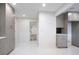 Bright kitchen featuring gray cabinets, white countertops, and white tiled floors, with a hallway leading to the front door at 4605 Doss Cir, Powder Springs, GA 30127