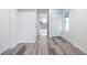 View of a room with gray wood-look floors, white walls, a window, and an open doorway into the kitchen at 4605 Doss Cir, Powder Springs, GA 30127