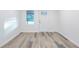 Neutral room featuring gray wood-look floors, a white door, and a window at 4605 Doss Cir, Powder Springs, GA 30127