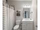 Bathroom with a vanity sink, toilet, and shower-tub combination with a decorative curtain at 4790 Epps Ln, Cumming, GA 30040
