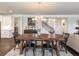 An inviting dining room features a wooden table, an elegant chandelier, and seamlessly connects to the kitchen and staircase at 4790 Epps Ln, Cumming, GA 30040