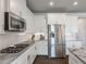 Well-equipped kitchen featuring granite counters, herringbone backsplash, and stainless appliances at 4790 Epps Ln, Cumming, GA 30040