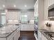 Contemporary kitchen with granite countertops, white cabinetry, and modern appliances at 4790 Epps Ln, Cumming, GA 30040
