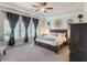 An elegant main bedroom features a tray ceiling, large windows, and stylish furnishings with neutral tones at 4790 Epps Ln, Cumming, GA 30040