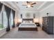 A luxurious main bedroom boasts a tray ceiling, neutral tones, and large windows for ample natural light at 4790 Epps Ln, Cumming, GA 30040