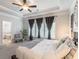 A bright main bedroom with tray ceiling offers a view of the ensuite bathroom and a cozy seating area near large windows at 4790 Epps Ln, Cumming, GA 30040
