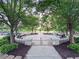 Picturesque outdoor seating area with stone benches nestled among mature trees in a serene park setting at 4790 Epps Ln, Cumming, GA 30040
