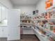 A well-organized pantry boasts shelving stocked with various food items and essentials, next to a white door and matching cabinets at 4790 Epps Ln, Cumming, GA 30040