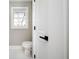 Bright bathroom featuring a toilet, window, and white flooring at 3241 Broadnax Mill Rd, Loganville, GA 30052