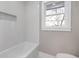 Bright bathroom featuring white tiling, a window, and neutral wall color at 3241 Broadnax Mill Rd, Loganville, GA 30052
