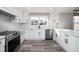 Well-lit kitchen with white cabinets, stainless steel appliances, and modern fixtures at 3241 Broadnax Mill Rd, Loganville, GA 30052