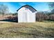 White outbuilding features black trim and sits on a lot surrounded by a chain link fence at 3241 Broadnax Mill Rd, Loganville, GA 30052