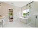Luxurious bathroom with a standalone tub, glass-enclosed shower, and marble tile flooring at 3525 Brynhurst Dr, Cumming, GA 30028
