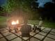 Atmospheric view of a cozy outdoor fire pit with Adirondack chairs in a serene backyard setting at 3525 Brynhurst Dr, Cumming, GA 30028