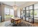 Bright home office featuring a modern chandelier, a wooden desk, and stylish glass-paneled walls at 3525 Brynhurst Dr, Cumming, GA 30028