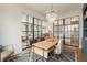 Open office space featuring a modern chandelier, a wooden desk, and stylish glass-paneled walls at 3525 Brynhurst Dr, Cumming, GA 30028