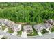 Aerial view of houses on a tree-lined street, showcasing lush green lawns and backyard play equipment at 3939 Soft Wind Ter, Buford, GA 30518