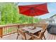 Wooden deck with outdoor dining set and a red umbrella, perfect for enjoying outdoor meals and relaxation at 3939 Soft Wind Ter, Buford, GA 30518