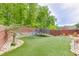 Lush backyard featuring a trampoline, swing, and well-manicured turf, perfect for outdoor activities and relaxation at 3939 Soft Wind Ter, Buford, GA 30518
