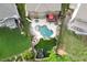 Backyard aerial view of an in-ground pool, with lounge chairs, outdoor seating, and a lush green lawn at 3939 Soft Wind Ter, Buford, GA 30518