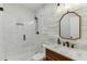Well-lit bathroom features white tiled walk-in shower, granite counters, wood accent wall and vanity mirror at 3939 Soft Wind Ter, Buford, GA 30518