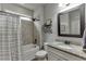 Well-lit bathroom with a shower-tub combo, granite counters, framed mirror, and neutral tile at 3939 Soft Wind Ter, Buford, GA 30518