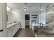 Modern bathroom featuring granite countertops, a walk-in shower, and a separate tub with sleek, neutral tile and fixtures at 3939 Soft Wind Ter, Buford, GA 30518