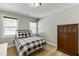 Cozy bedroom featuring hardwood floors, natural light, a checkered comforter and wooden dresser at 3939 Soft Wind Ter, Buford, GA 30518