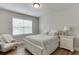 Cozy bedroom with a queen bed, accent chair, nightstand, and a bright window with blinds at 3939 Soft Wind Ter, Buford, GA 30518