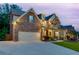 Inviting stone and brick home with a well-manicured lawn, beautiful landscaping, and a two-car garage at 3939 Soft Wind Ter, Buford, GA 30518