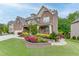 Charming home with manicured lawn, retaining wall flower garden, and stone/siding exterior, set among lush trees at 3939 Soft Wind Ter, Buford, GA 30518