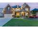 Beautiful two-story home featuring a manicured lawn, charming front porch, and stone and siding exterior at 3939 Soft Wind Ter, Buford, GA 30518