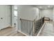Bright upstairs hallway with hardwood floors, black iron railing, and white trim at 3939 Soft Wind Ter, Buford, GA 30518