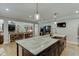Kitchen area view with large island, seating, open view into living room, and a stainless refrigerator at 3939 Soft Wind Ter, Buford, GA 30518