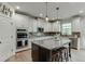 Kitchen with white cabinets, tile backsplash, granite counters, and a dark wood island at 3939 Soft Wind Ter, Buford, GA 30518