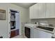 Well-equipped laundry room with washer, dryer, and ample cabinet space, plus direct access to a walk-in closet at 3939 Soft Wind Ter, Buford, GA 30518