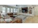 Cozy living room with a large brown leather sectional couch, ceiling fan and custom built-in shelving at 3939 Soft Wind Ter, Buford, GA 30518