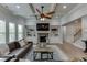 Spacious living area featuring a stone fireplace, built-in shelving, and a coffered ceiling with a ceiling fan at 3939 Soft Wind Ter, Buford, GA 30518