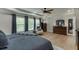 Bright primary bedroom featuring hardwood floors, tray ceiling, ceiling fan, and large windows at 3939 Soft Wind Ter, Buford, GA 30518